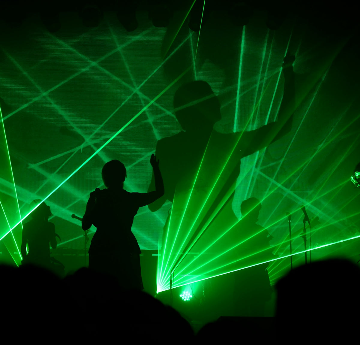 Silhouettes on stage with green laser lights